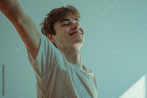 A young man holding a Nintendo Wii game controller. Suitable for gaming or technology-related projects photo