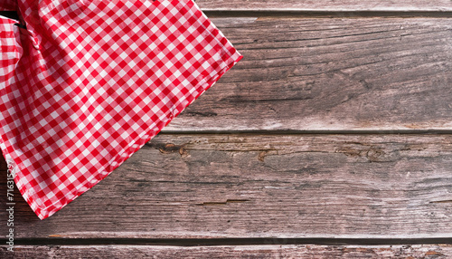 Red checkered napkin on a rustic wooden table with copy space for placing your text or product. Italian, homemade, traditional kitchen. High quality photo