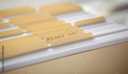 Yellow folders with labels and paper in a row in the insurance file closeup