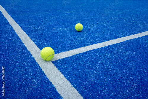 two paddle tennis balls over the line of a paddle tennis court © VicVaz
