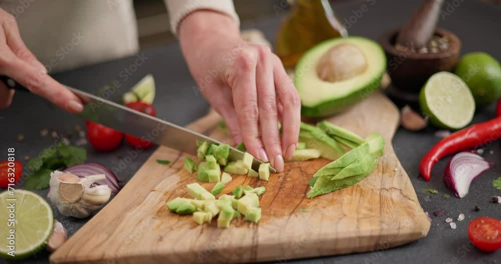 Salsa recipe - Woman chopping and cutting Fresh green avocado fruit on a wooden board at domestic kitchen Salsa recipe - Woman chopping and cutting Fresh green avocado fruit on a wooden board at domestic kitchen