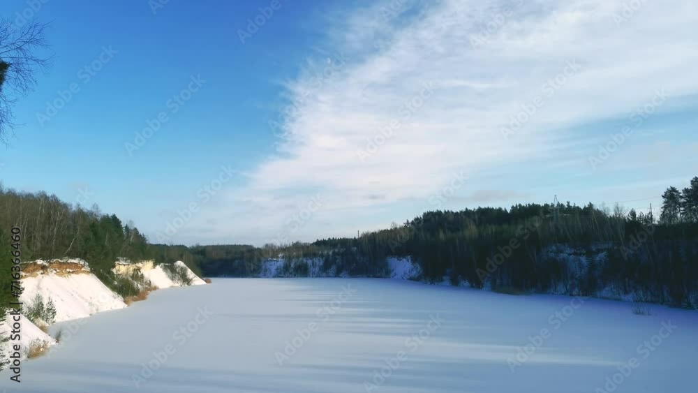 Amazing 4k time lapse of frozen land with lake in winter, dramatic cloudscape - establishing shot. The shadows of the trees stretch out in length as the sun sets. Amazing 4k time lapse of frozen land with lake in winter, dramatic cloudscape - establishing shot. The shadows of the trees stretch out in length as the sun sets.