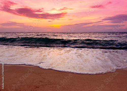 Sunset scene with wave water in the Tropical summer beach with sandy beach background
