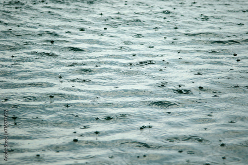 On the shore, heavy rain during the day. Rain drops are remarkable effect on the sea surface.