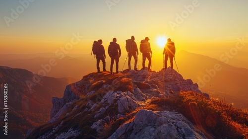 Group of Hikers Standing on Mountain Peak at Sunrise Celebrating Team Success