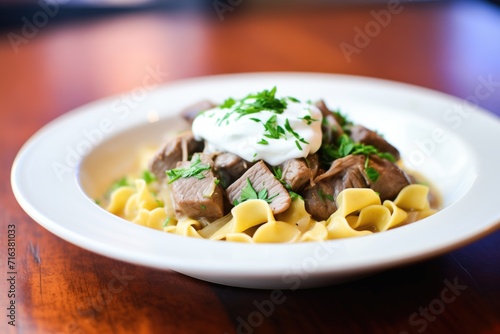 beef stroganoff served over egg noodles with a dollop of sour cream