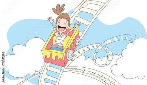Girl child rides roller coaster at the amusement park.