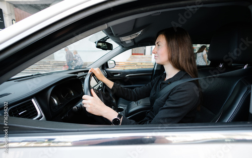 Woman in black clothes driving luxurious car © 4Max