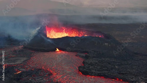 Aerial drone view over active volcanic crater eruption. Hot lava and magma coming out of the crater. Tourist attraction in Iceland Litlihrutur eruption 2023. Beautiful and dangerous disaster. photo
