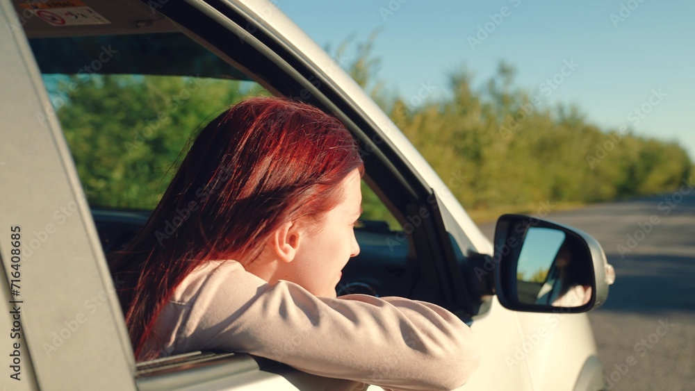 girl rides car with her hand out window, conceptual car journey along road, outdoor entertainment, beautiful young woman smiling sunset, traveling by car camper, hand movements from window sunset