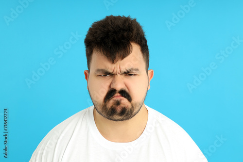 Fényképezés Upset overweight man on a blue background.