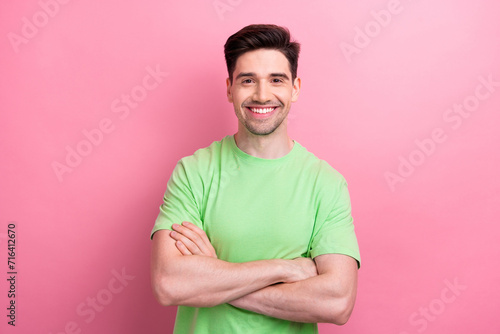 Portrait of handsome businessman folded arms wearing casual green t shirt without dress code in office isolated on pink color background