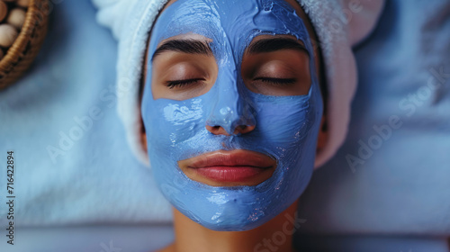 Lifestyle portrait of woman at luxury spa with blue face mask treatment, Close up