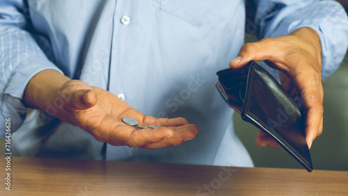 Poor man bankrupt with no credit in debt hand hold empty black leather wallet because economy down turn Empty wallet  no money  in the hands of an man