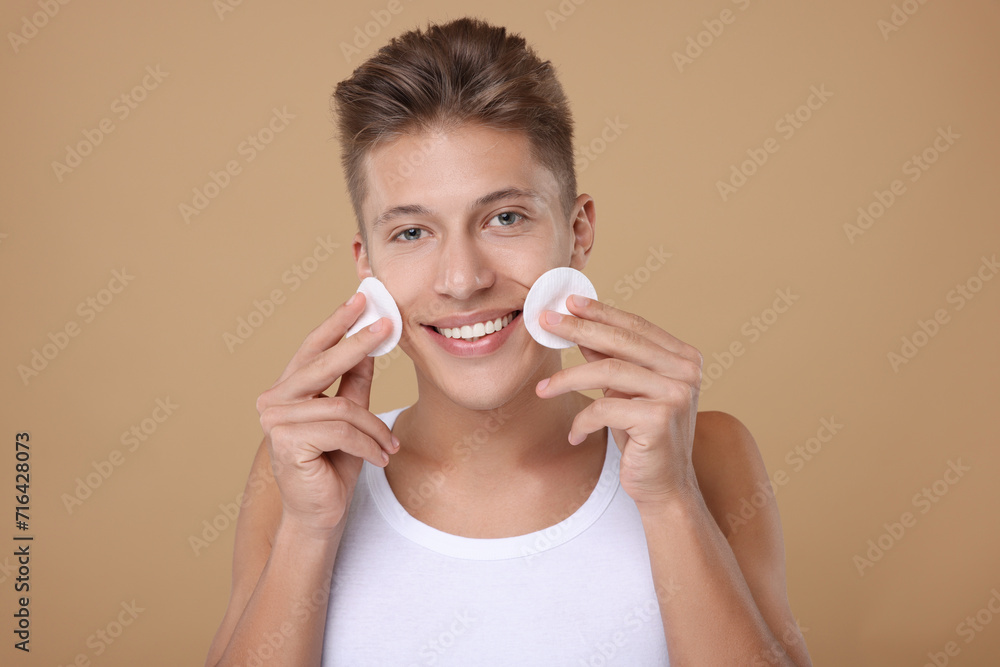 Handsome man with cotton pads on beige background Handsome man with cotton pads on beige background
