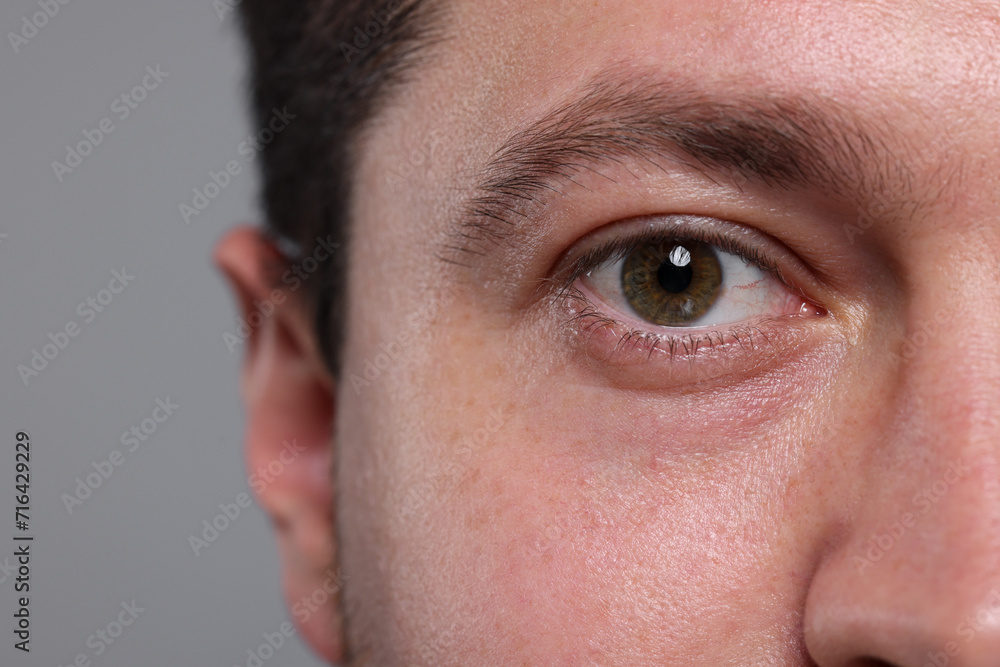 Obraz premium Closeup view of man with beautiful eyes on grey background