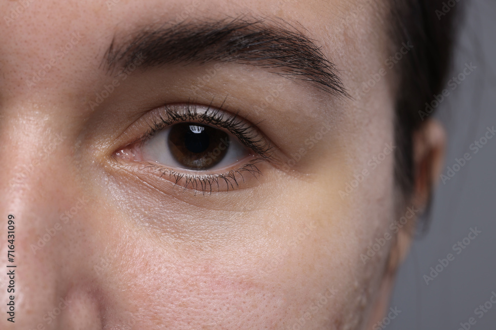 Fototapeta premium Closeup view of woman with beautiful eyes on grey background