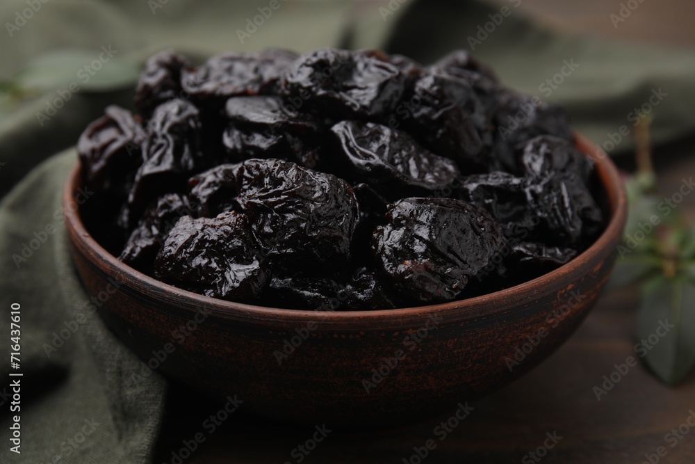 Sweet dried prunes in bowl on table, closeup Sweet dried prunes in bowl on table, closeup