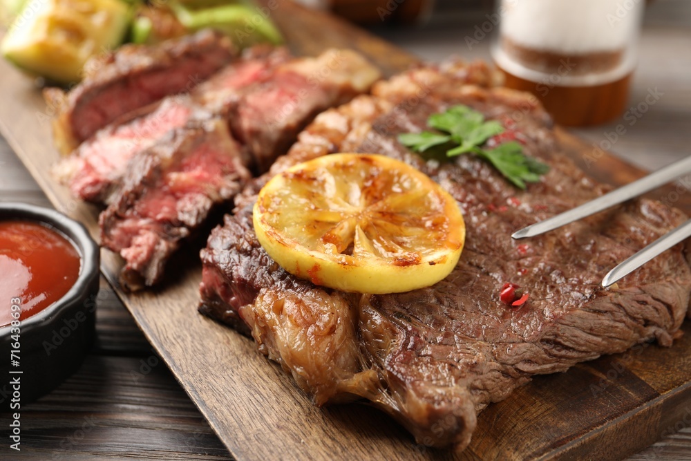 Delicious grilled beef steak on wooden table, closeup