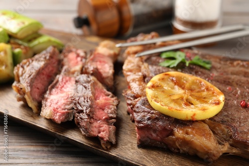 Delicious grilled beef steak on wooden table, closeup