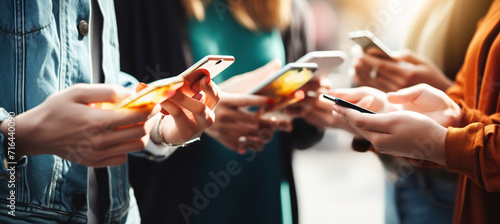 Group of young people using smart mobile phone device outside photo