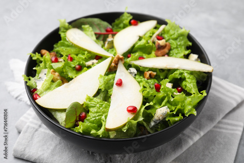 Delicious pear salad in bowl on table, closeup