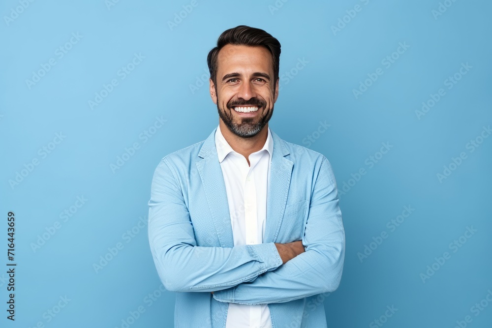 Portrait of handsome smiling man with crossed arms standing against blue background. Portrait of handsome smiling man with crossed arms standing against blue background.