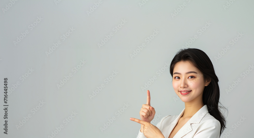 Asian woman presents, pointing with copy space yellow background, portrait beauty, confidence, and elegance of a young and attractive Asian model. Asian Beauty and fashionable concept Asian woman presents, pointing with copy space yellow background, portrait beauty, confidence, and elegance of a young and attractive Asian model. Asian Beauty and fashionable concept