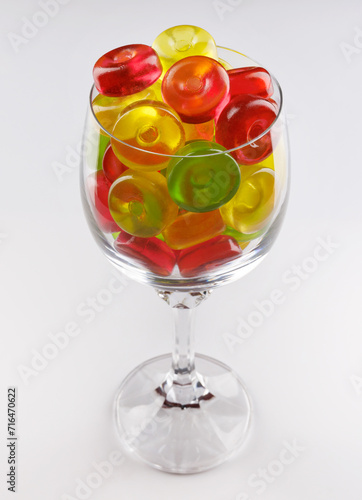 Glass goblet full of beautiful multi-colored candies. Multi-colored candies in a glass goblet.