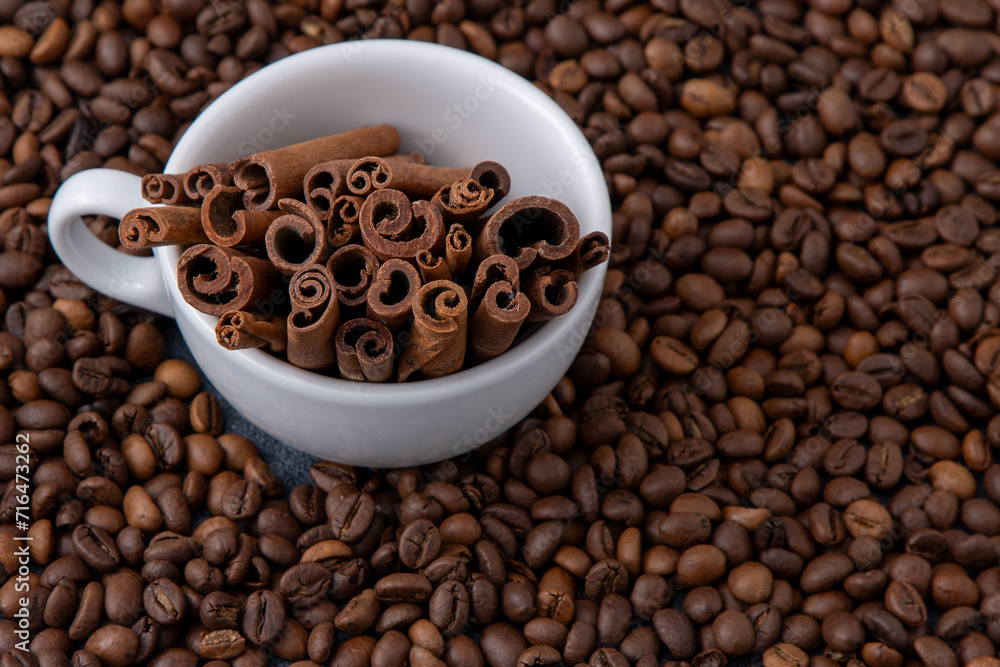 Coffee beans and cinnamon sticks in a cup. Food drink background Coffee beans and cinnamon sticks in a cup. Food drink background