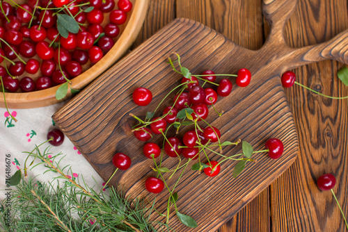 ripe cherries on a wooden plate. Harvest of red berries on a wooden background
