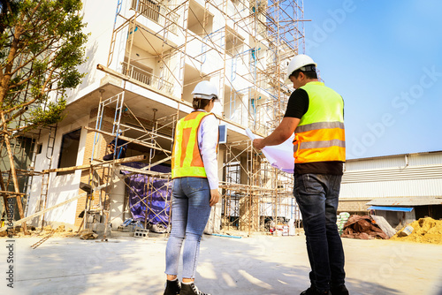 Εκτύπωση καμβά Rear view caucasian male and female architects oversee the construction of a new condominium