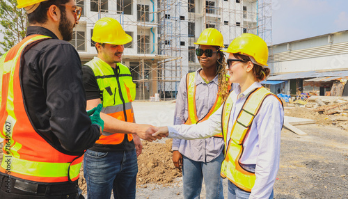 Teamwork handshake cooperation of architects and male and female workers multiethnicon on the apartment construction site condominium building for success in the project teamwork and achieving goals.