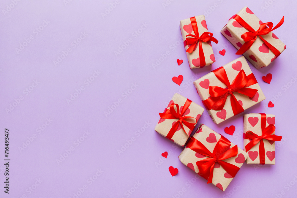 Top view photo of valentine day decorations gift box with red ribbon bow on colored background. Holiday gift boxes with top view Top view photo of valentine day decorations gift box with red ribbon bow on colored background. Holiday gift boxes with top view