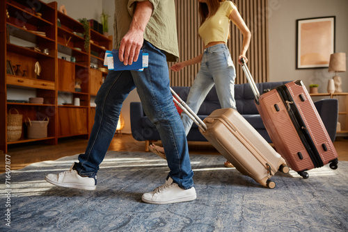 Closeup man and woman walking with luggage leaving home