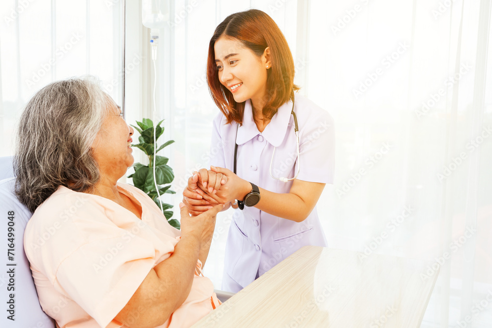 Female doctor holds the hand elderly female patient showing positive expressions encouragement good wishes each other heal sick person normal healthy spread happiness together in the hospital. Female doctor holds the hand elderly female patient showing positive expressions encouragement good wishes each other heal sick person normal healthy spread happiness together in the hospital.
