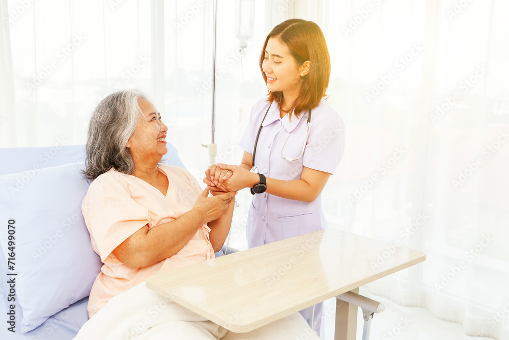 Obraz premium Female doctor holds the hand elderly female patient showing positive expressions encouragement good wishes each other heal sick person normal healthy spread happiness together in the hospital.