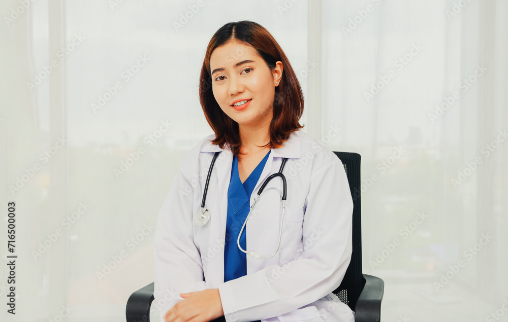 Female volunteer doctor physician surgeon in portrait in white uniform with gentle medical stethoscope sitting in a chair in the office relaxing smiling at the camera friendly to everyone. Female volunteer doctor physician surgeon in portrait in white uniform with gentle medical stethoscope sitting in a chair in the office relaxing smiling at the camera friendly to everyone.