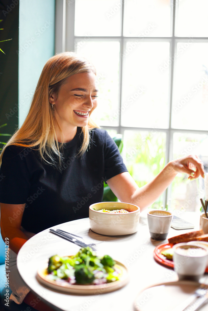 Cheerful woman enjoying coffee in cafe