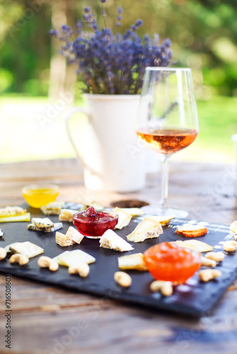 Grape, set of different kind of cheeses with a glass of pink wine on the table