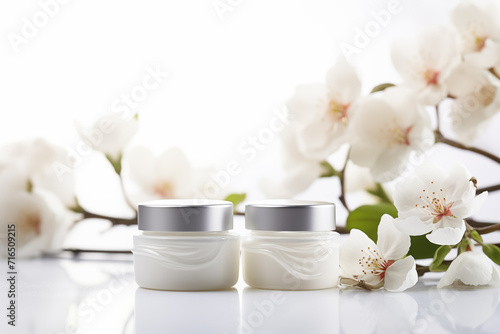 Cosmetic cream jars mockup on white background with spring flowers. Skin care product package design.