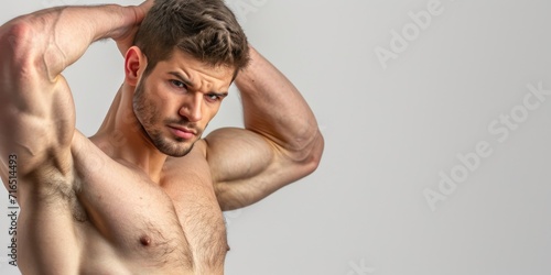 Handsome top model man bodybuilder flexing big wide shoulders, showing off muscles