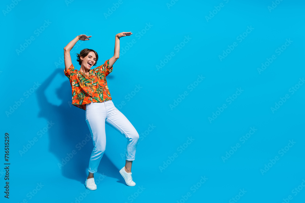 Full size portrait of excited lovely girl have good mood dancing show empty space offer isolated on blue color background