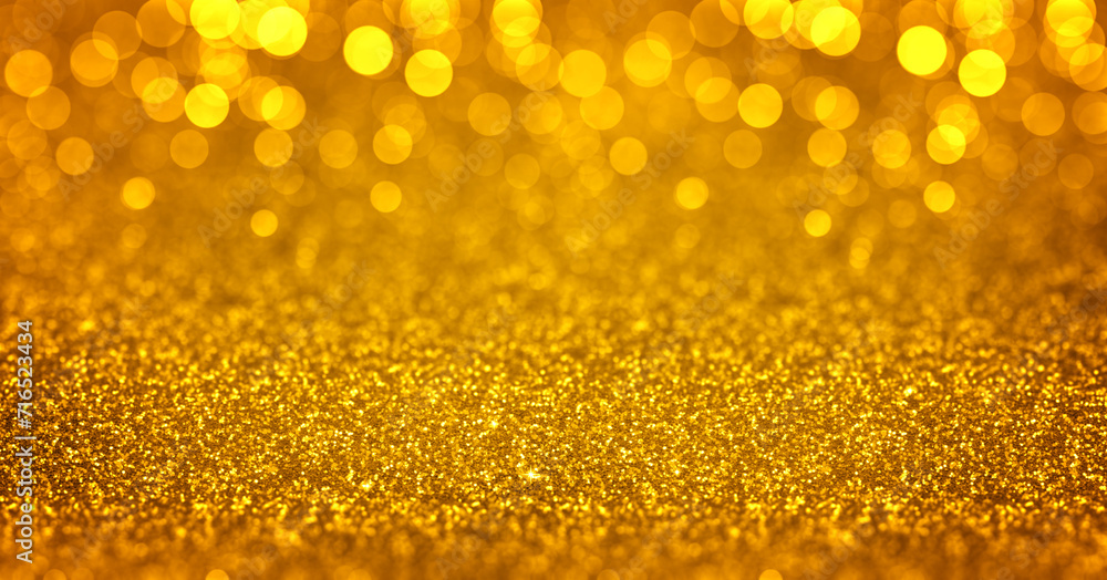 Sparkling golden glitter background with bokeh. Closeup view, dof. Pattern with shining fine gold sequins. Festive luxury golden background, backdrop, texture. Design element