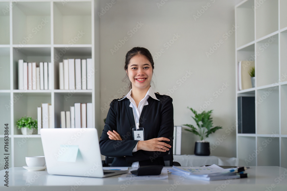 Portrait of happy and successful young Asian business woman employee in modern office Portrait of happy and successful young Asian business woman employee in modern office