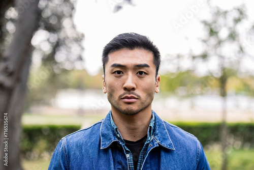 head shot portrait young adult of asian ethnicity looking at camera serious