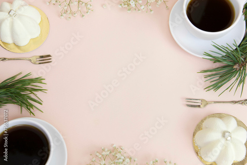 Filiżanki kawy i eleganckie białe babeczki ślubne. Z miejscem na tekst, na jasnym różowym tle. 