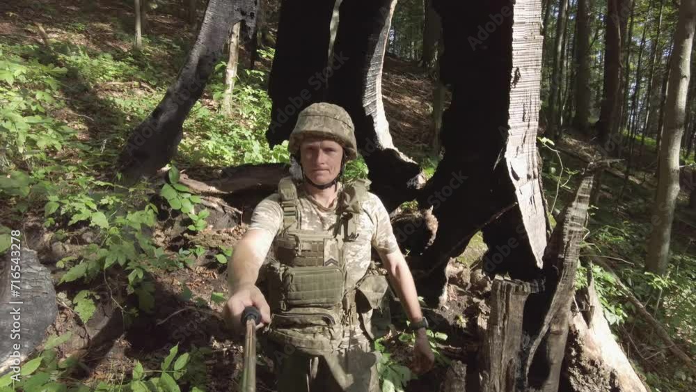 Ukrainian soldier explores the incredibly huge remnant of an ancient, centuries-old oak tree destroyed by lightning. artifact on top of a mountain in the Carpathians; Ukrainian soldier explores the incredibly huge remnant of an ancient, centuries-old oak tree destroyed by lightning. artifact on top of a mountain in the Carpathians;