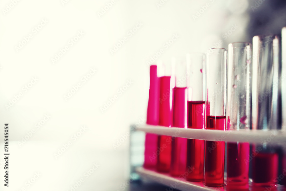 Microscopic examination of blood. Test tubes with red liquid on the laboratory table. Microscopic examination of blood. Test tubes with red liquid on the laboratory table.
