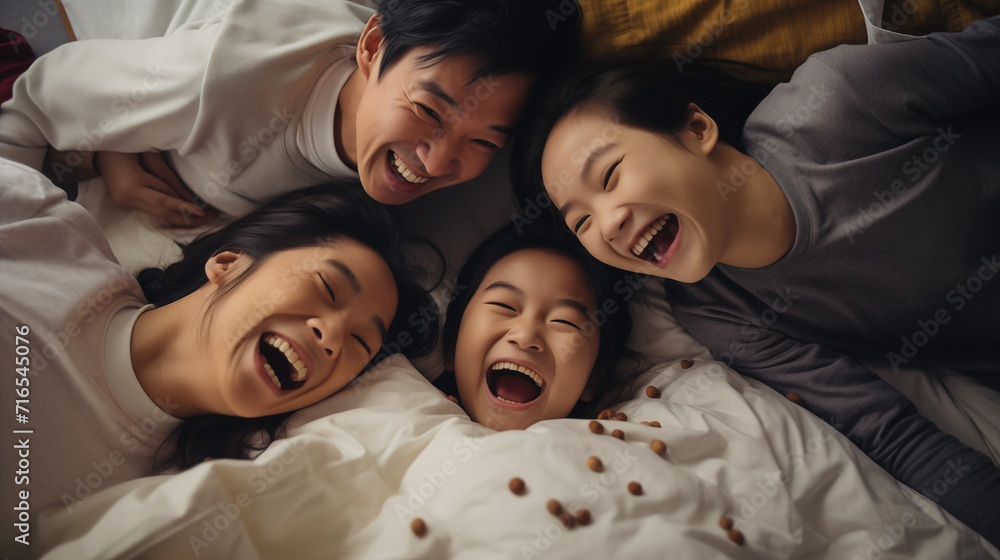 Happy Asian family lying on bed in bedroom with happy and smile, adorable moment. Happy Asian family lying on bed in bedroom with happy and smile, adorable moment.